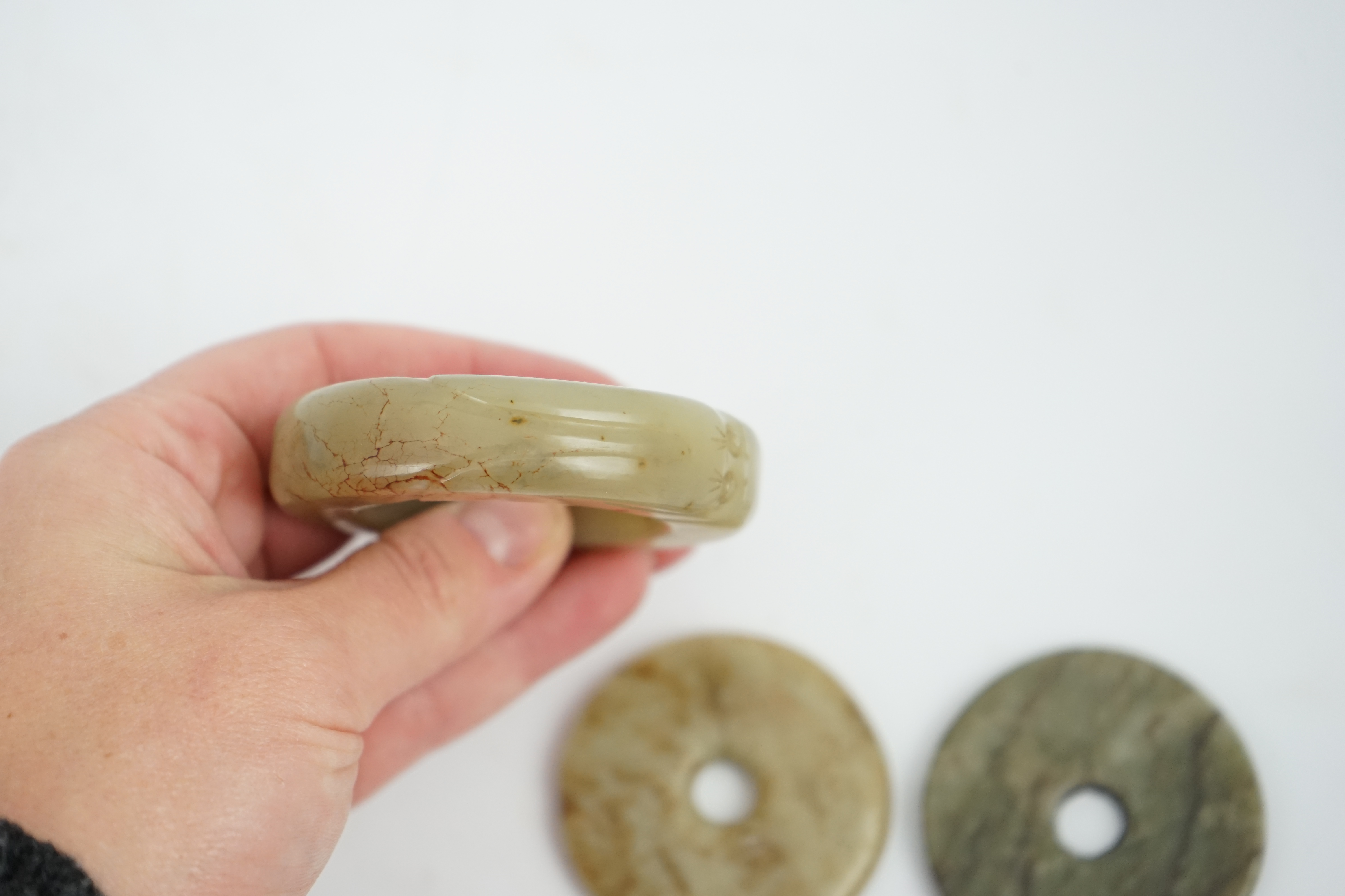 Two Chinese soapstone bi discs, and a jade ring, 18th century or earlier, largest 6.5cm in diameter. Condition - good